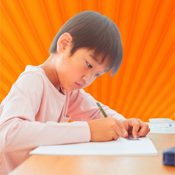 A young artist working hard on a kaiju drawing